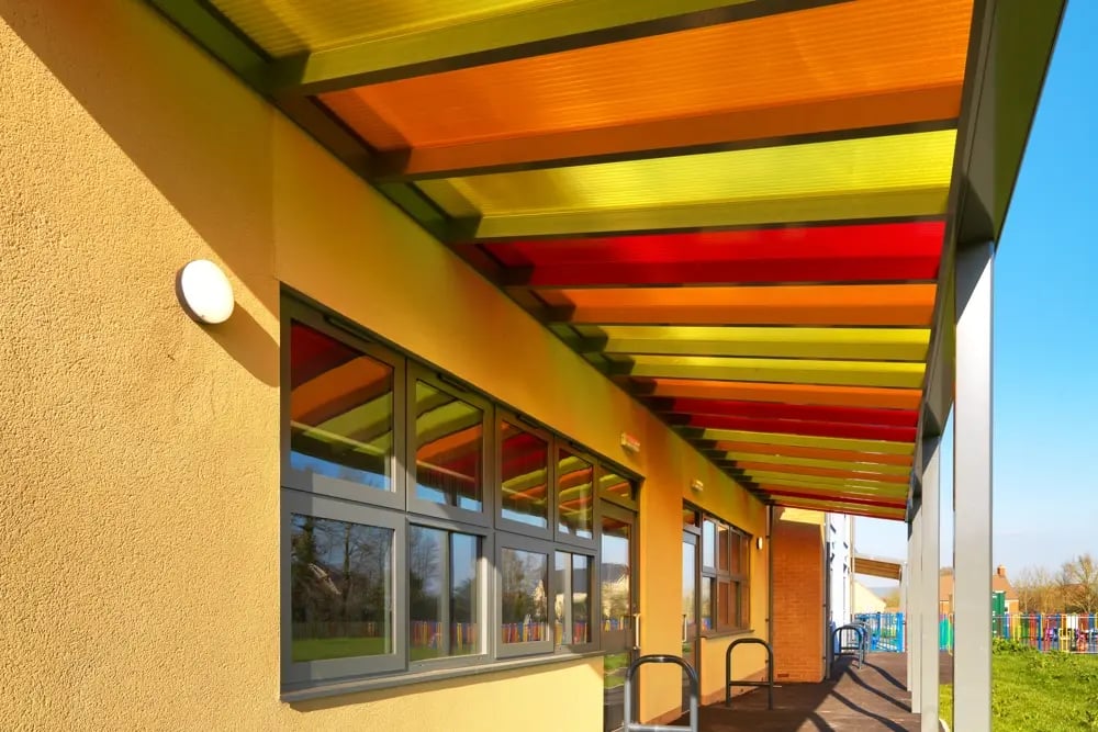 Standing underneath a school canopy with a red, orange and yellow roof